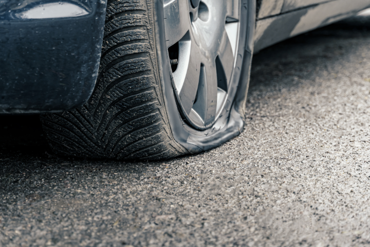 Close up of flat car tire, punctured wheel  