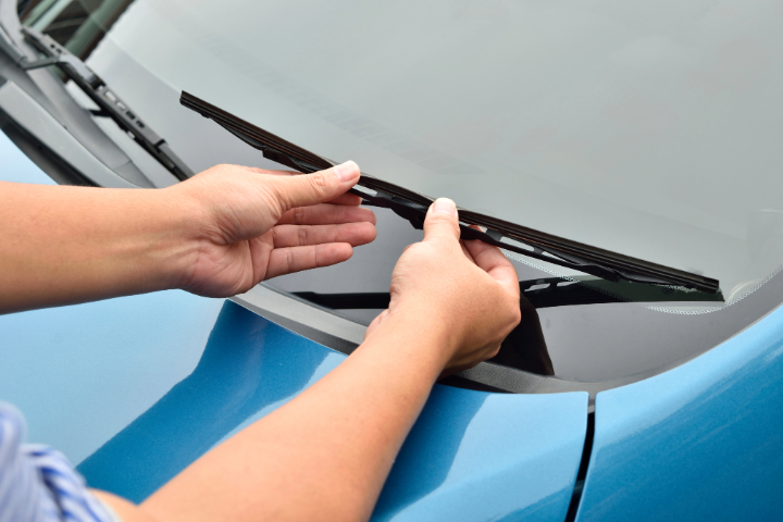 Hand picking up windscreen wiper